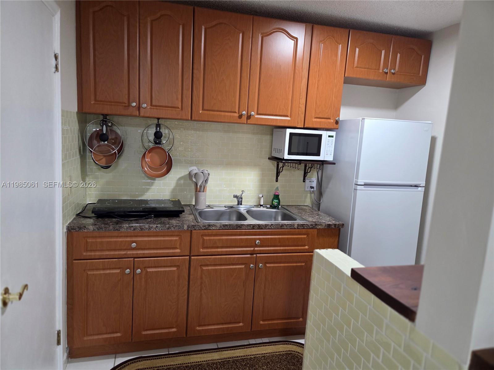 2931 Southwest 135th Avenue Miami, FL 33175 - Photo 9 of 20 a kitchen with granite countertop wood cabinets and stainless steel appliances