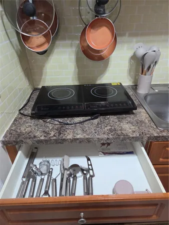 a kitchen sink with granite countertop a sink and a stove