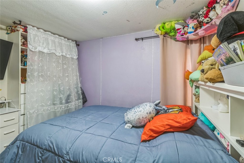 8221 Ilex Street, Unit 10 Rancho Cucamonga, CA 91739 - Photo 10 of 12 a bedroom with a bed and a potted plant