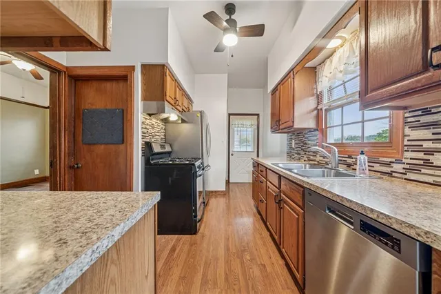 a kitchen with stainless steel appliances a refrigerator sink and microwave