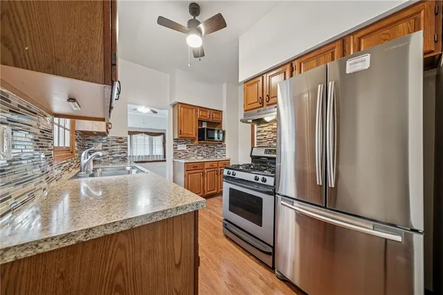 a kitchen with granite countertop cabinets a sink a window and stainless steel appliances