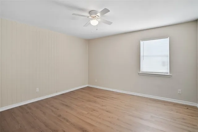 a view of a room with wooden floor and a ceiling fan
