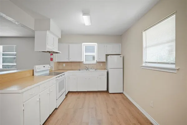 a kitchen with cabinets a sink and wooden floor