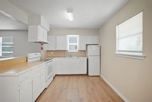 a kitchen with cabinets a sink and wooden floor
