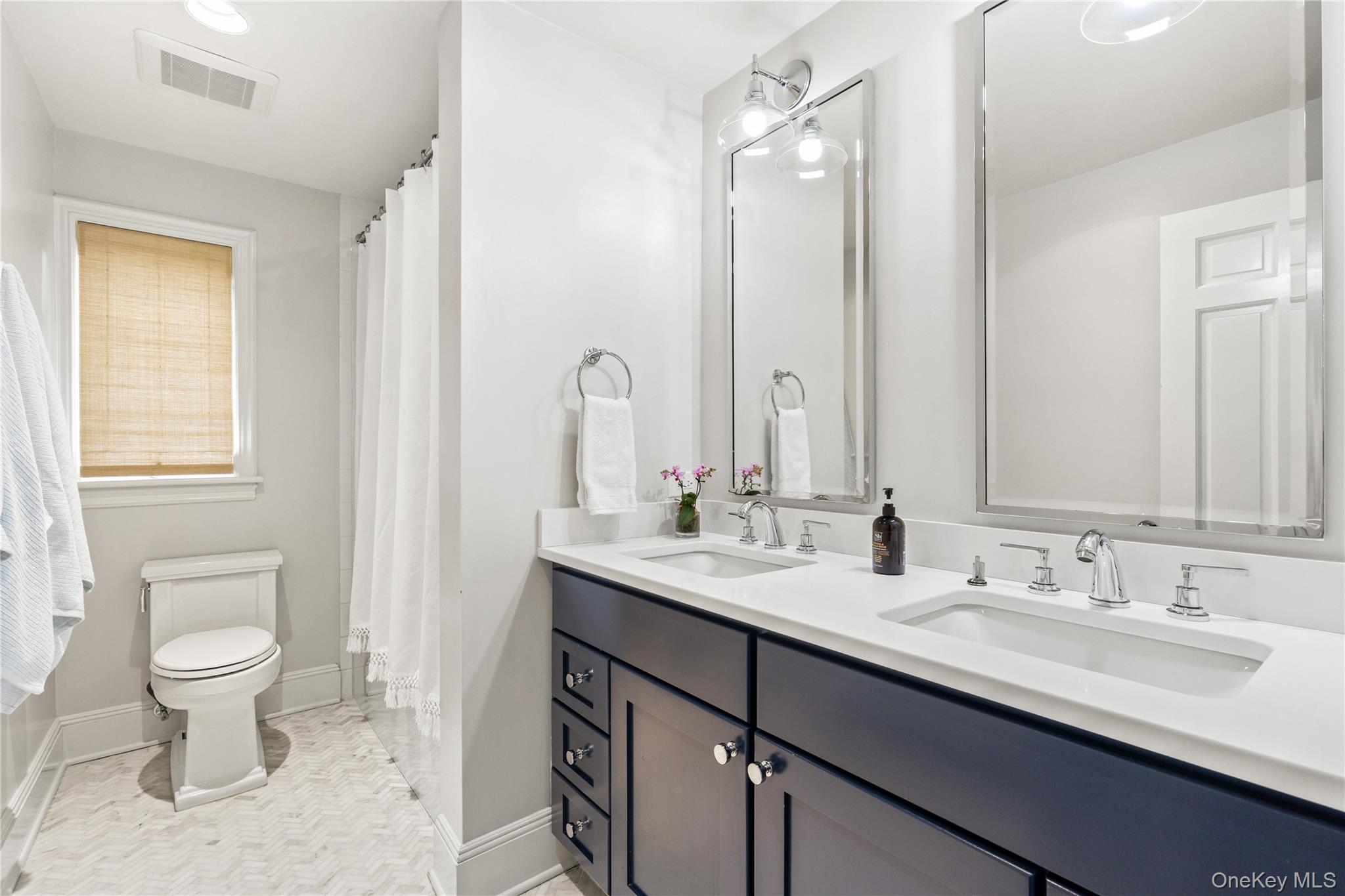 37 Bates Road Harrison, NY 10528 - Photo 22 of 41 a bathroom with a double vanity sink toilet and a mirror