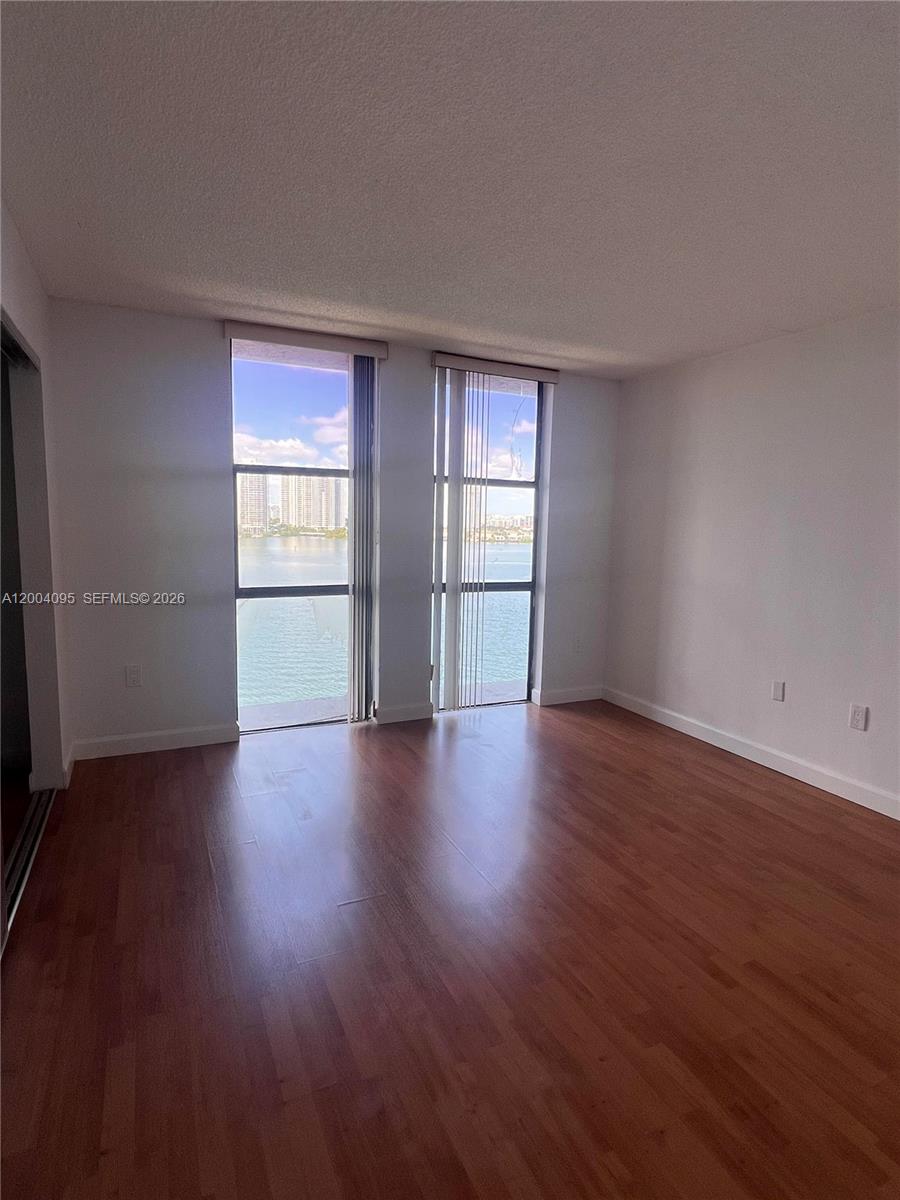 17500 North Bay Road, Unit S907 Sunny Isles Beach, FL 33160 - Photo 15 of 24 an empty room with wooden floor and window