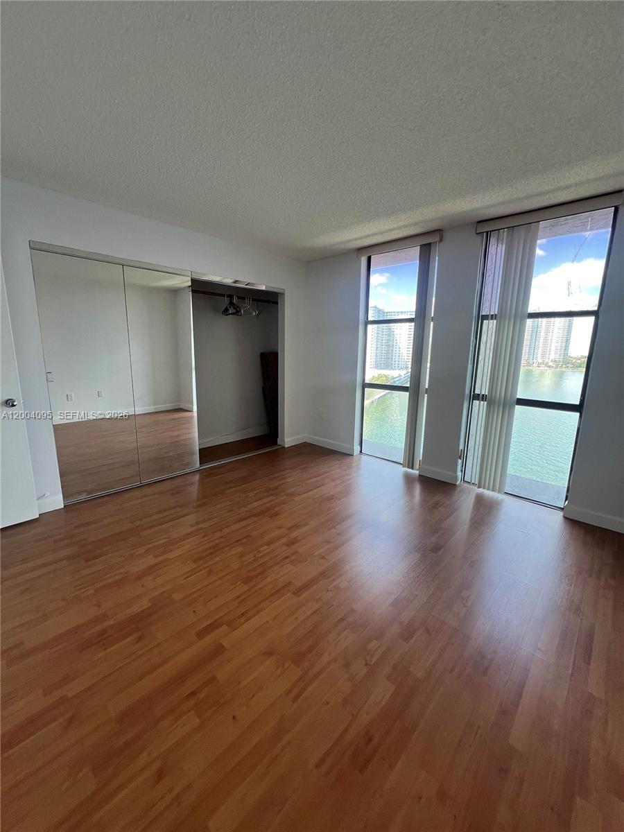 17500 North Bay Road, Unit S907 Sunny Isles Beach, FL 33160 - Photo 16 of 24 an empty room with wooden floor and windows