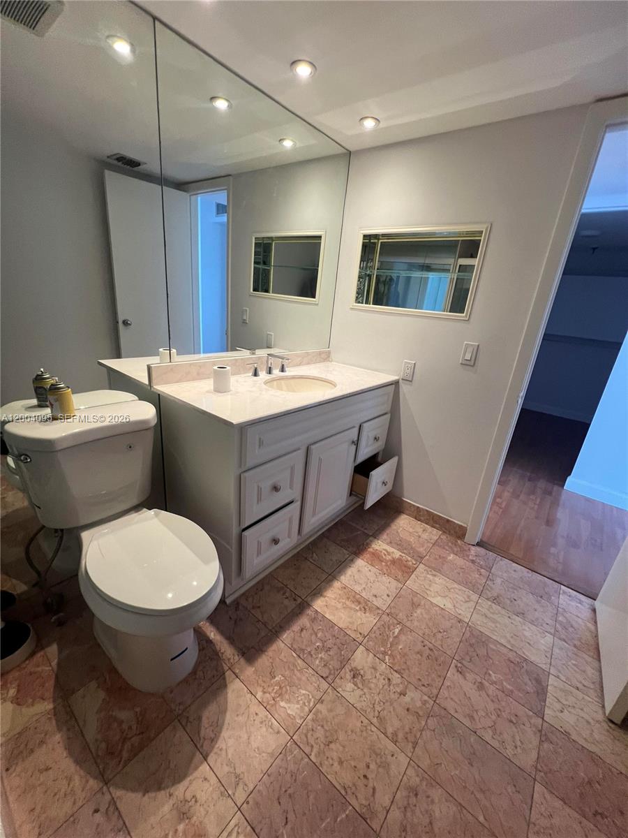 17500 North Bay Road, Unit S907 Sunny Isles Beach, FL 33160 - Photo 22 of 24 a bathroom with a toilet sink and mirror