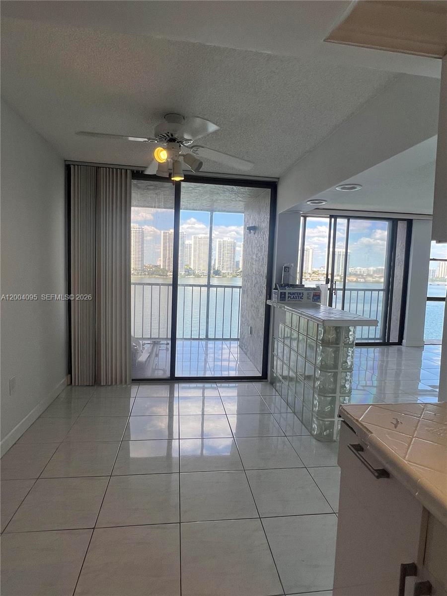 17500 North Bay Road, Unit S907 Sunny Isles Beach, FL 33160 - Photo 5 of 24 an empty room with windows and chandelier
