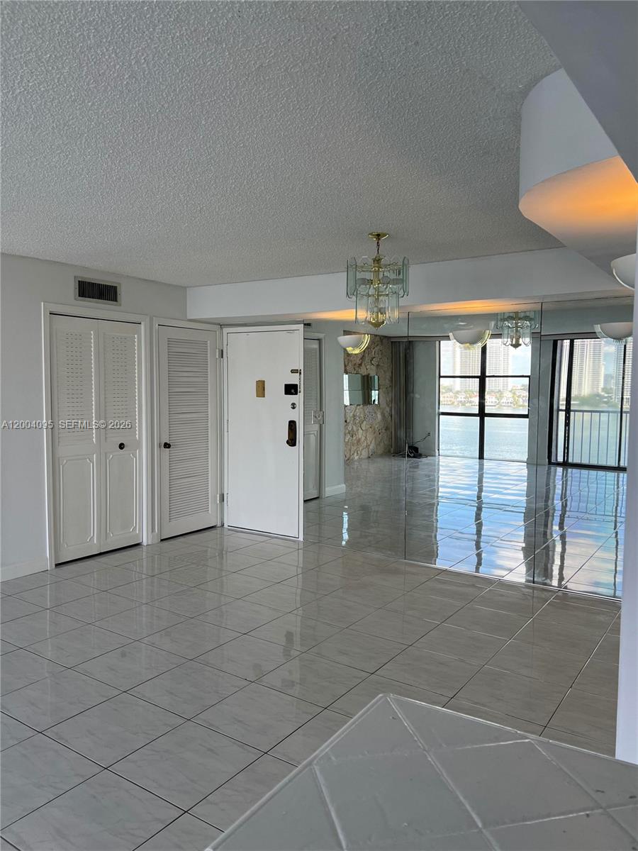 17500 North Bay Road, Unit S907 Sunny Isles Beach, FL 33160 - Photo 10 of 24 a view of a hallway with chandelier and entryway