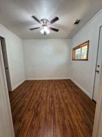a view of empty room with wooden floor