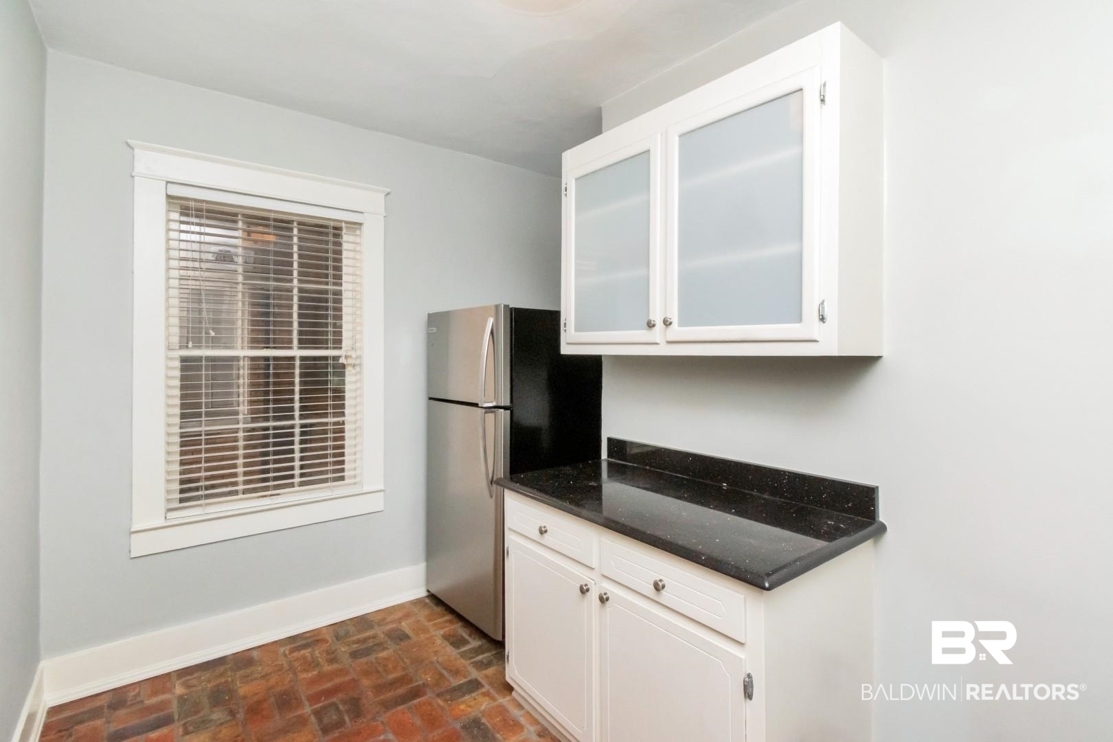1602 Government Street, Unit 1A Mobile, AL 36604 - Photo 8 of 24 Kitchen with white cabinets, brick flooring, and dark stone counters