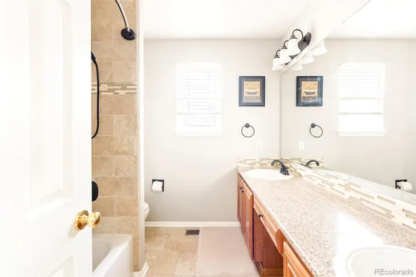 a spacious bathroom with a granite countertop sink a toilet and shower