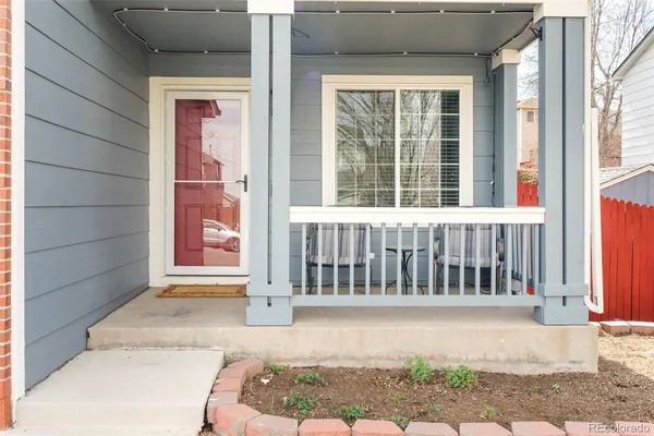 a view of a house with a small yard and wooden floor and fence