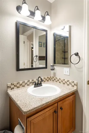 a bathroom with a granite countertop sink and a mirror