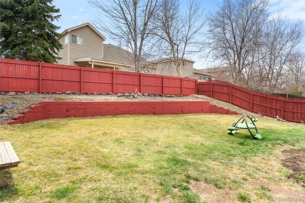 a view of backyard with wooden fence