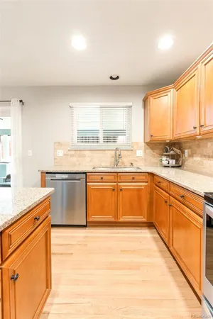 a kitchen with a stove a sink and white cabinets