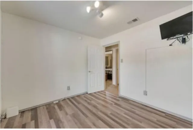 a view of a livingroom with wooden floor and a flat screen tv