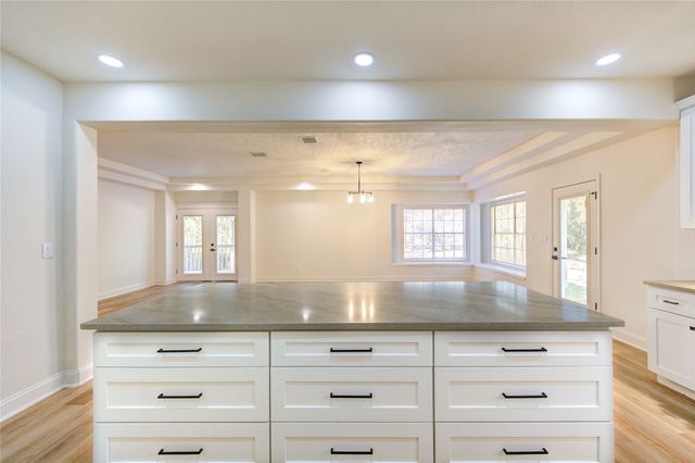 a kitchen with granite countertop white cabinets and white appliances
