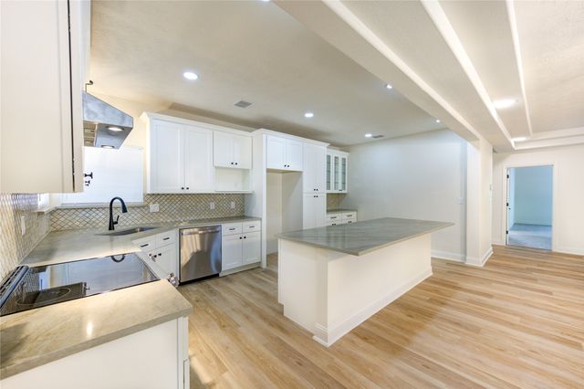 a large kitchen with stainless steel appliances granite countertop a sink a stove and a refrigerator