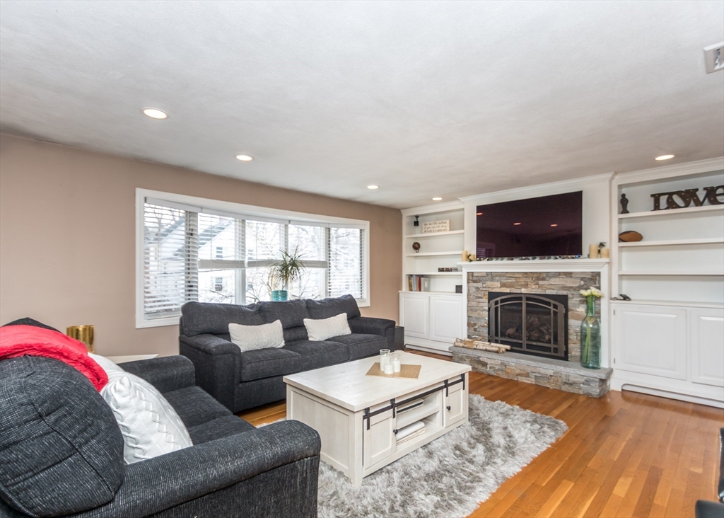 27 Sherman Street Needham, MA 02494 - Photo 2 of 32 a living room with furniture a fireplace and a flat screen tv