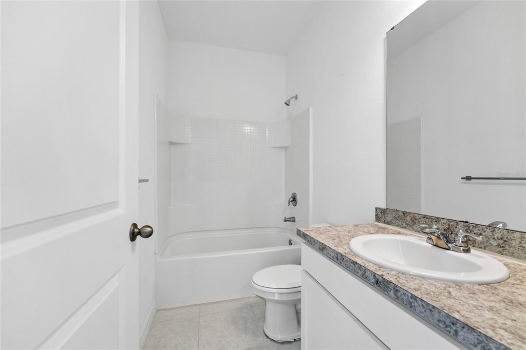 5875 Herder Road St. Cloud, FL 34771 - Photo 21 of 42 a bathroom with a granite countertop sink toilet and shower