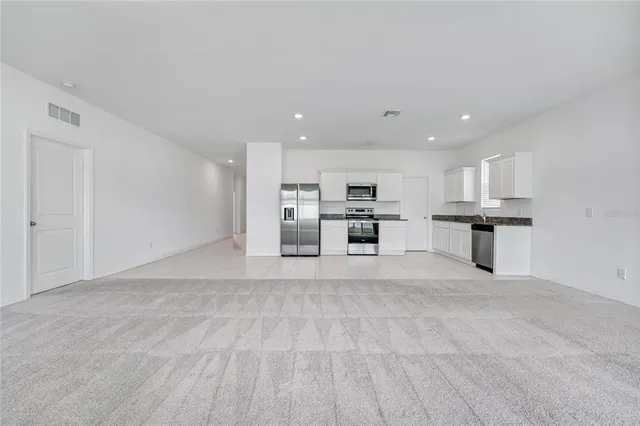 a view of kitchen with refrigerator sink and stove