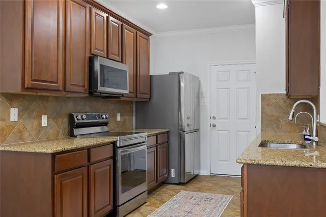 a kitchen with stainless steel appliances granite countertop a refrigerator sink and stove