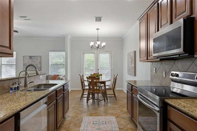a kitchen with granite countertop a sink stove and cabinets