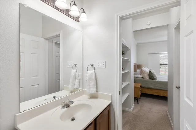 a en suite bathroom with a double vanity sink and a mirror