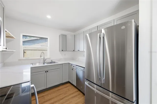 a kitchen with stainless steel appliances a refrigerator sink and cabinets