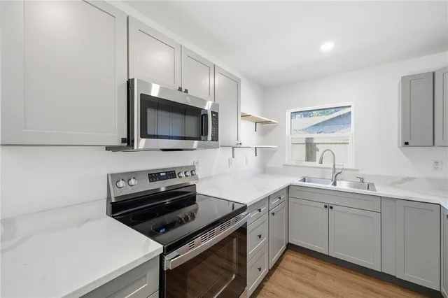 a kitchen with a sink stove and microwave