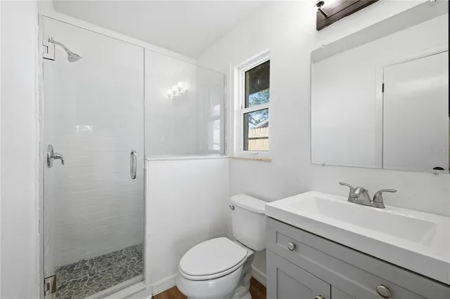 a bathroom with a sink a toilet and shower