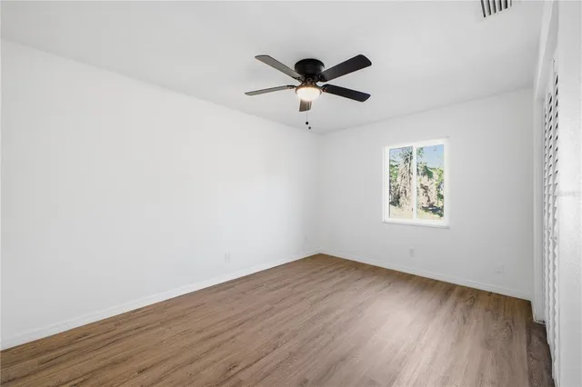 a view of empty room with wooden floor