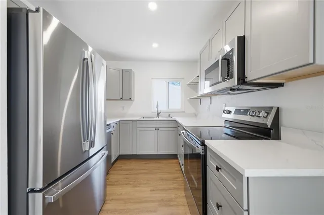 a kitchen with stainless steel appliances a refrigerator sink and microwave