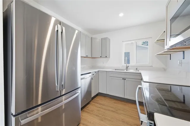 a kitchen with white cabinets and refrigerator