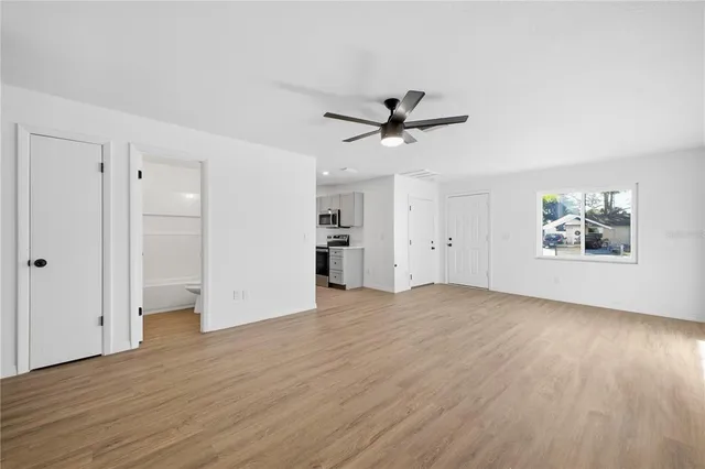 an empty room with wooden floor and windows