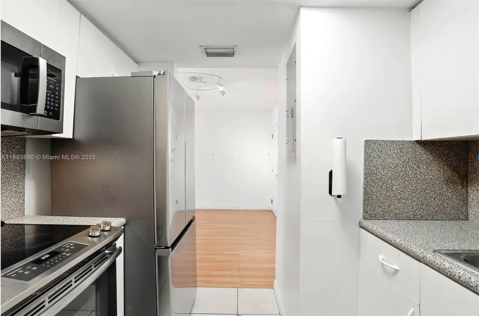 2415 Northwest 16th St Road, Unit 2031 Miami, FL 33125 - Photo 4 of 7 a kitchen with a refrigerator and a stove