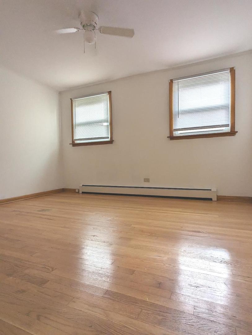 6134 West 79th Street, Unit 1 Burbank, IL 60459 - Photo 13 of 19 a view of an empty room with wooden floor and a window