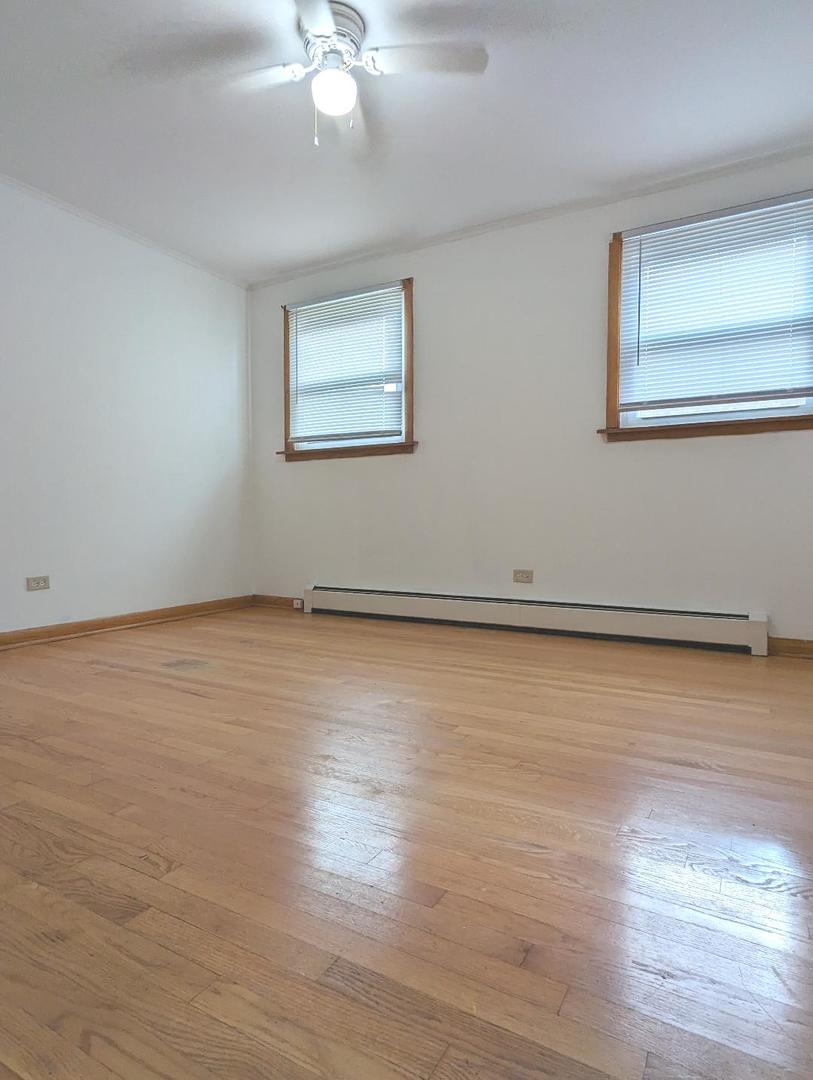 6134 West 79th Street, Unit 1 Burbank, IL 60459 - Photo 14 of 19 a view of an empty room with wooden floor and a window