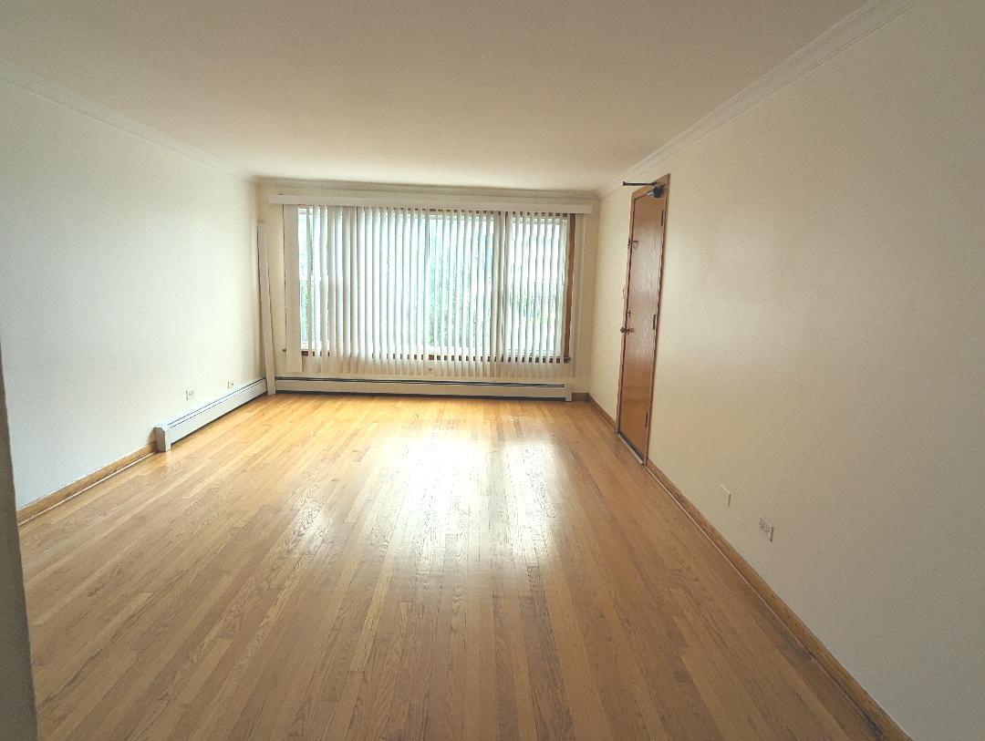 6134 West 79th Street, Unit 1 Burbank, IL 60459 - Photo 3 of 19 wooden floor in an empty room with a window