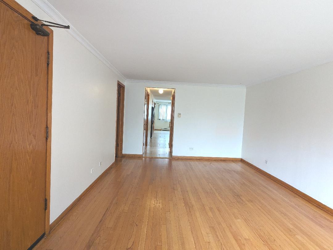 6134 West 79th Street, Unit 1 Burbank, IL 60459 - Photo 4 of 19 a view of an empty room with wooden floor and a window