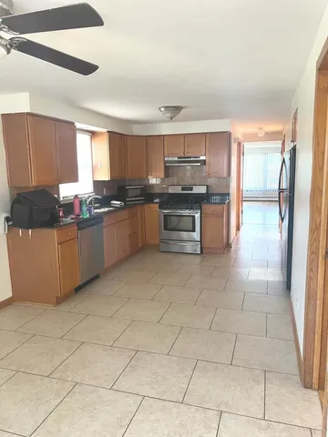 a kitchen with stainless steel appliances a sink a stove top oven a counter space and cabinets