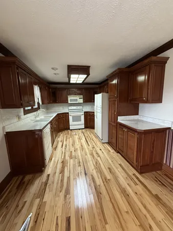 a kitchen with a sink and wooden floor
