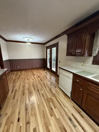 a living room with table chairs and wooden floor