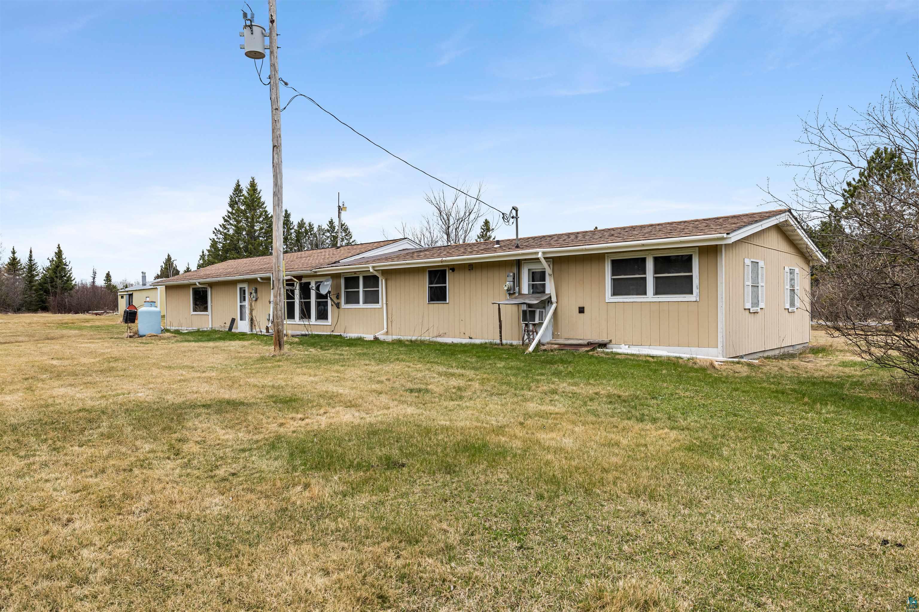 11574 Town Line Road Hibbing, MN 55746 - Photo 28 of 41 Expansive side yard featuring a grass lawn and mature trees in the background