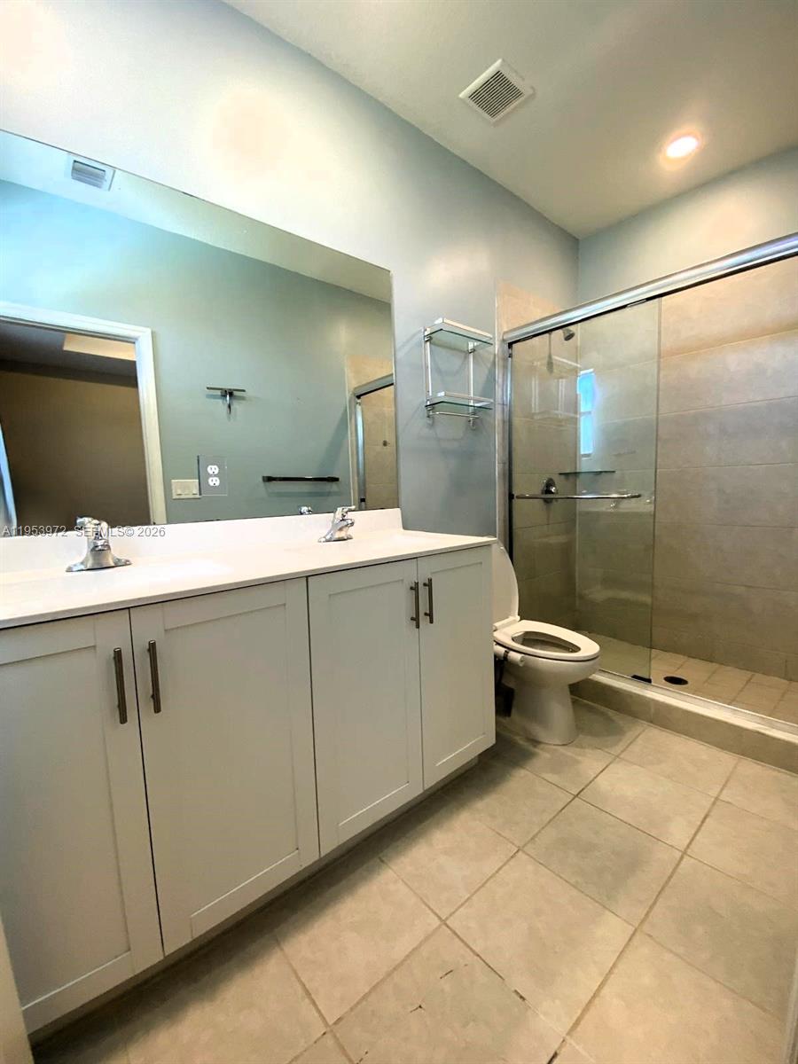 18220 Southwest 148th Road Miami, FL 33187 - Photo 12 of 23 a bathroom with a double vanity sink toilet and shower