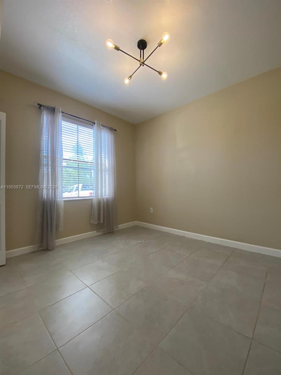 18220 Southwest 148th Road Miami, FL 33187 - Photo 2 of 23 an empty room with windows and ceiling fan