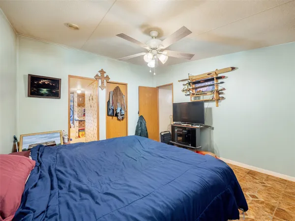 a bed room with a bed a television and dresser