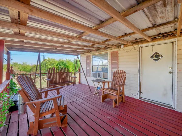 a view of a porch with furniture and wooden floor